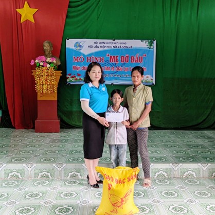Đại diện lãnh đạo Hội LHPN huyện trao hỗ trợ em Lục Lam Thuyên, thôn En, xã Sơn Hà