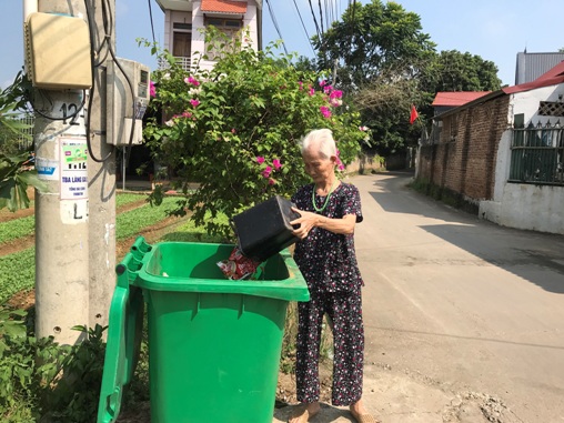 Ảnh: Người dân thôn Trường Sơn đổ rác vào thùng thu gom